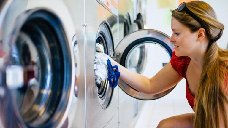 Taking clothes out of washing machine at onsite laundry facility