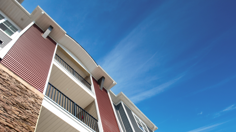 Looking up at apartment building against sky